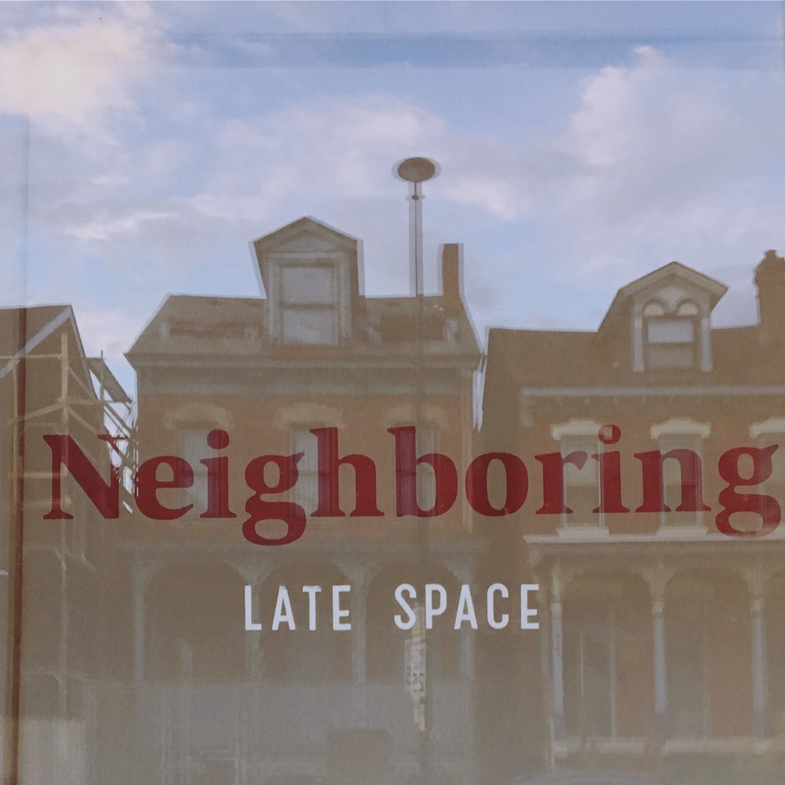 photograph of Neighboring sign through windows reflecting houses