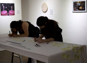 Photograph of women writing in the gallery